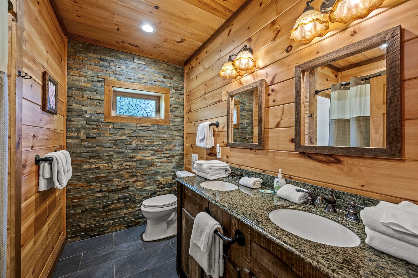 Lower level: Granite and reclaimed wood dual vanity in lower level's spacious bath with tub/shower combo